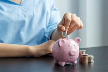 women putting coin in piggy bank. saving money, budget, investment, finance concept