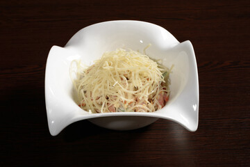 Tender and delicious vegetable salad with bacon seasoned with mayonnaise and sprinkled with cheese. Photos for restaurant and cafe menus