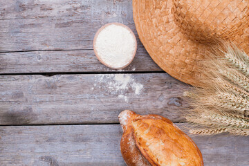 Bread, flour and wheat ears. Artisan bread on wooden background. Rural still life.