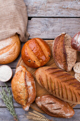 Organic bread assortment on wooden background. Various types of fresh homemade bread, top view.