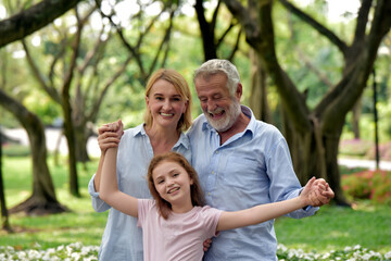Fototapeta premium happy family of father, mother and daughter in park . Family and Insurance concept.