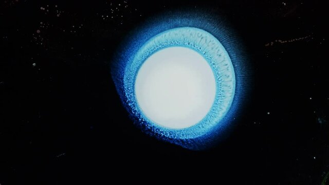 Silver, Blue, and White sun solar flare reaction with liquid ink / paint drop stain on black background / oil bleed bloom / Big Bang explosion of supernova star 4K