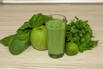 Green smoothie on light wooden background. Healthy smoothie veggies cocktail. Green vegetables and fruits.