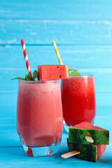 Watermelon juice smoothie with slices watermelon and mint drinks for summer in the glass on blue wooden table background.