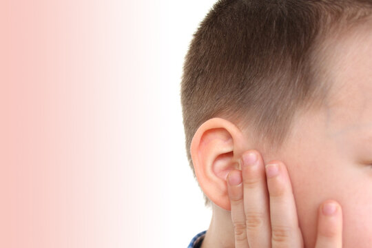 little boy holds on to the ear, part of the face close-up, medical concept, hearing control, middle ear inflammation, otitis media