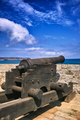 Fototapeta na wymiar Fort-La-Latte, Brittany, France. Cannon in the castle pointed towards the sea. Summer day, blue sky with beautiful clouds.