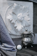 artistic still life in monochrome tones with a metal jug and a plaster flower