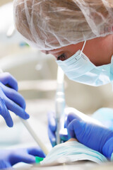 Portrait of a pediatric dentist during surgery under General anesthesia. Removal of deep caries. Copy of the space.Vertical photo.