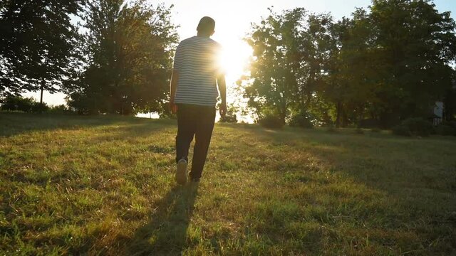 The guy walks in the park, sun rays