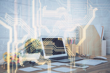 Computer on desktop in office with technology theme hologram. Double exposure. Tech concept.