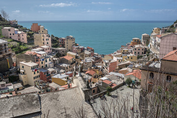 View of Riomaggiore village, first & most southern of Cinque Terre coastal villages, located in a small & narrow valley, as seen from east towards the Mediterranean sea, La Spezia, Liguria region, Ita