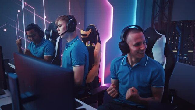 Diverse Esport Team of Pro Gamers Play in Computer Video Game and Win Championship, Celebrate with High-Fives. Neon Cyber Games Arena. Online Streaming of Tournament. Side Gliding Dolly View