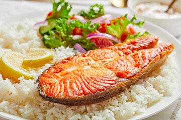 fried trout steak served with rice and salad