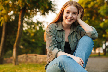Cheerful young woman sitting in a park