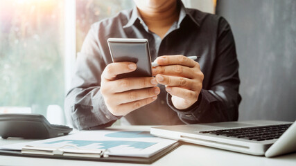businesswoman hand using smart phone,mobile p payments online shopping,omni channel,digital tablet docking keyboard computer at office in sun light