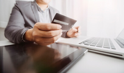 businesswoman hand using smart phone, tablet payments and holding credit card online shopping, omni channel, digital tablet docking keyboard computer at office in sun light