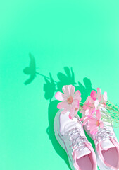 Stylish summer white sneakers and flowers. Fashion still life concept