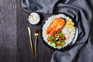 fried salmon steak served with rice and salad