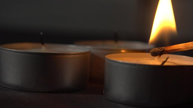 Lighting up two tealights with a match, slow motion
