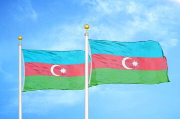 Azerbaijan and Azerbaijan two flags on flagpoles and blue sky