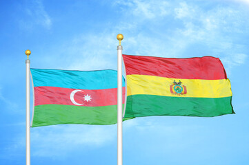 Azerbaijan and Bolivia two flags on flagpoles and blue sky