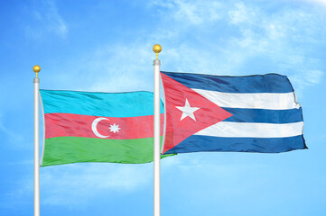 Azerbaijan and Cuba two flags on flagpoles and blue sky