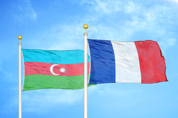 Azerbaijan and France two flags on flagpoles and blue sky