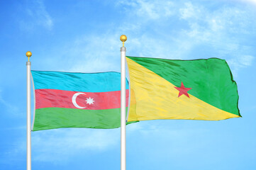 Azerbaijan and French Guiana two flags on flagpoles and blue sky
