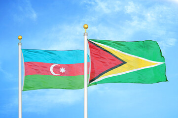 Azerbaijan and Guyana two flags on flagpoles and blue sky