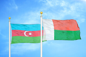 Azerbaijan and Madagascar two flags on flagpoles and blue sky