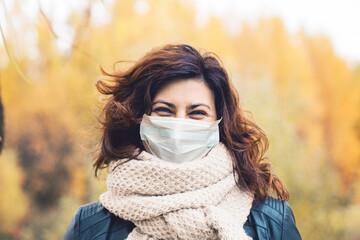 Autumn woman in medical protective face mask walking outdoors, fall season portrait