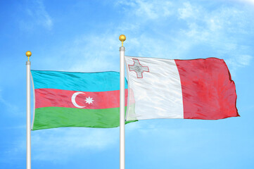 Azerbaijan and Malta two flags on flagpoles and blue sky