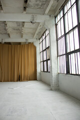 industrial white hall with huge windows and brown cloth on one of the wall background