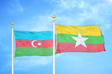 Azerbaijan and Myanmar two flags on flagpoles and blue sky