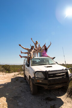 Young people on top of a 4WD in the sunshine