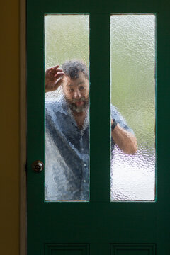 Man looking in through frosted glass door