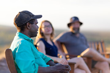 Three people relaxing on chairs outdoors