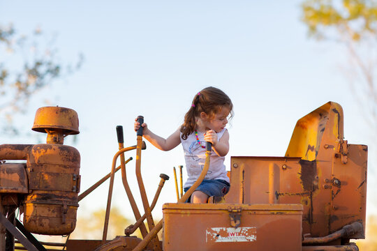 Little kid pretending to drive an old dozer