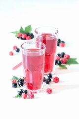 Berry drink, compote of fresh raspberries and black currants in a glass on a white background
