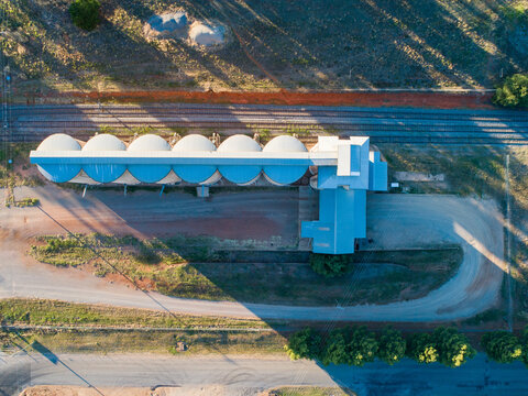 Overhead aerial photo of grain silos next to train line