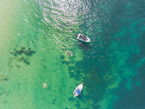 Looking down on boats and canoes afloat on the ocean