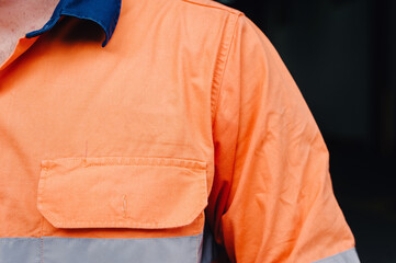 man's shoulder in hi vis workshirt with copyspace for logo
