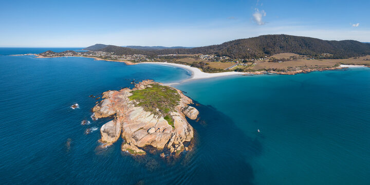 Aerial view of a rocky island off the coast of a sandy beach