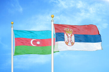 Azerbaijan and Serbia two flags on flagpoles and blue sky