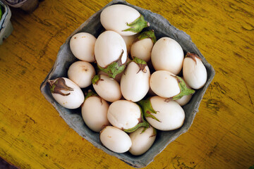 Container of white baby eggplants