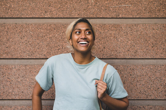 happy young student leading against wall