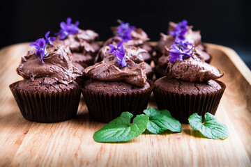 Chocolate cup cakes with frosting and flowers