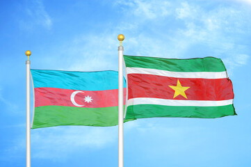 Azerbaijan and Suriname two flags on flagpoles and blue sky