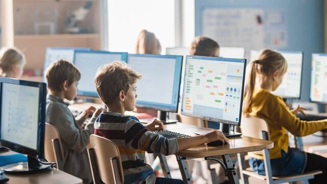 Elementary School Computer Science Classroom: Smart Little Schoolchildren Work on Personal Computers, Learn Programming Language for Software Coding. Schoolchildren Getting Modern Education