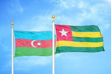Azerbaijan and Togo two flags on flagpoles and blue sky